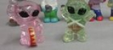 Anyone know what either of these lil guys are called? I know they are vending machine toys but don’t know the name or brand. The clear aliens look bigger than the normal aliens from the old vending machines.